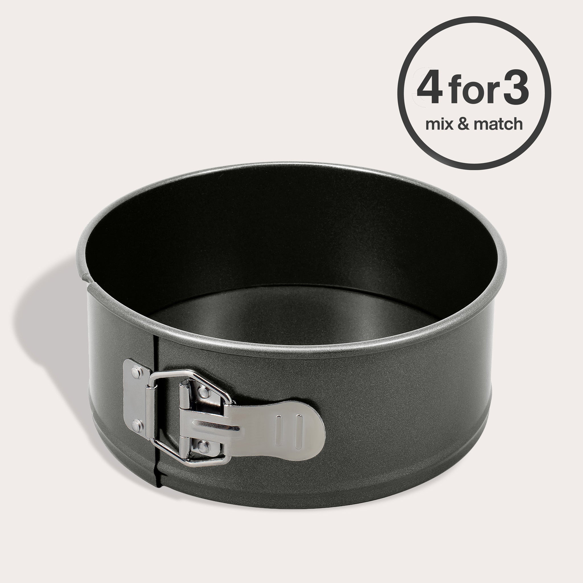 The Zyliss Non-Stick Springform Cake Pan, round and black with a silver latch, rests on a light surface. A circular label in the top right corner says "4 for 3 mix & match.