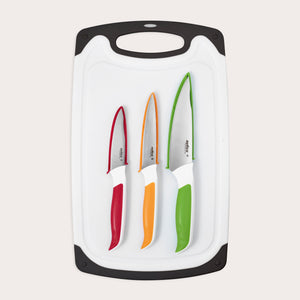 The Zyliss 4 Piece Comfort Board and Knife Set features a white board with black edges, holding three dishwasher-safe Japanese stainless steel knives with colored handles in red, orange, and green arranged from smallest to largest.