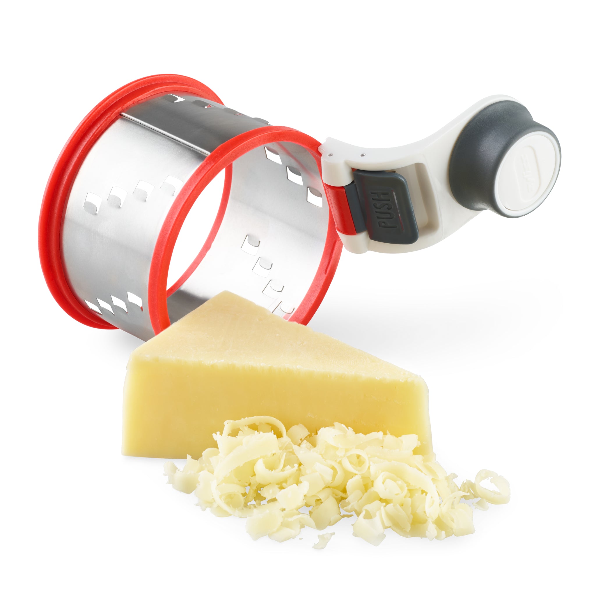 A rotary cheese grater with a red and silver drum beside a wedge of hard cheese and a small pile of freshly grated cheese on a white background.