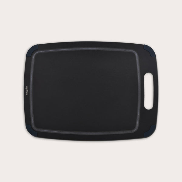 The Zyliss Wood Fibre Cutting Board, black and rectangular with a handle and rounded corners, made from recycled wood fibres, is shown on a light background. #Large