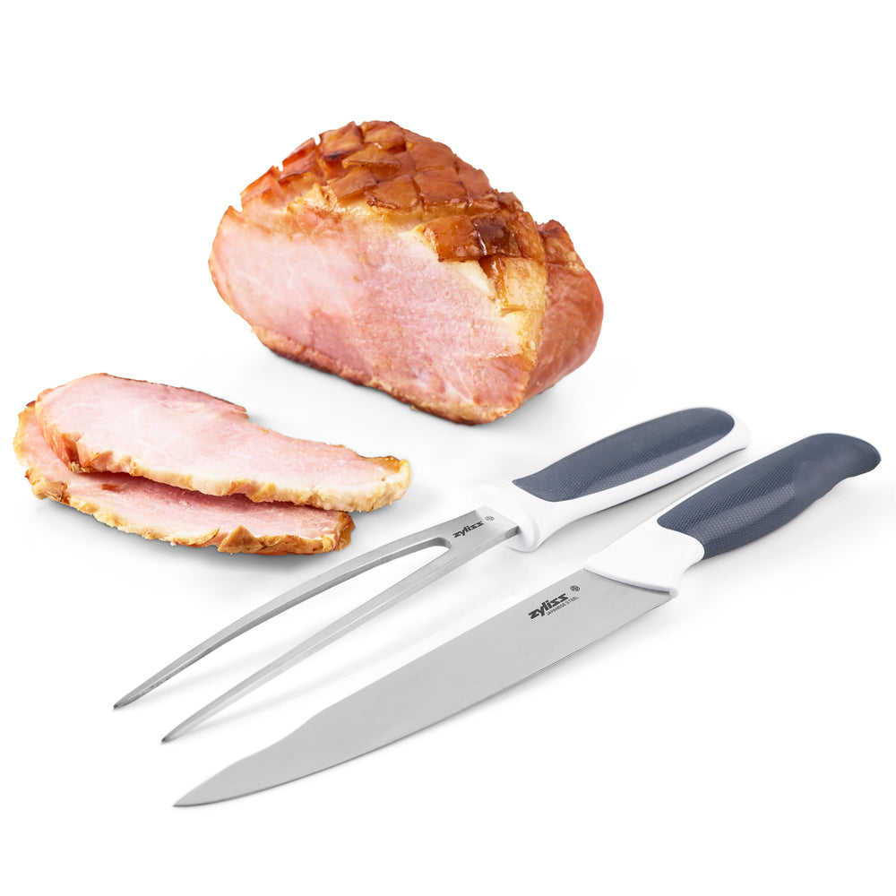 The Zyliss Comfort Carving Knife 18.5cm (7¼) with a black and white handle and comfortable grip is pictured beside its black protective sheath on a plain light background.