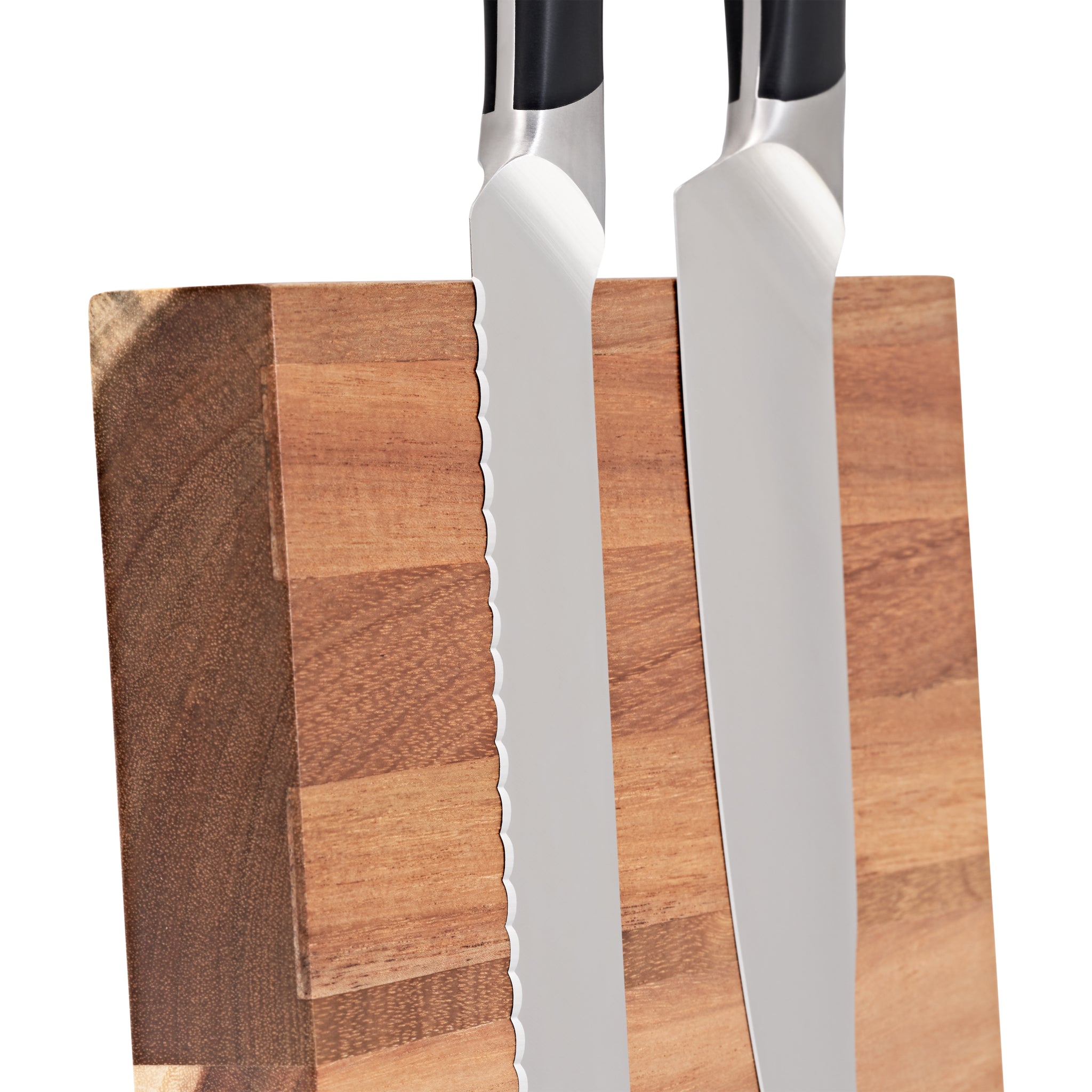 Close-up of two kitchen knives, one serrated and one smooth-edged, standing upright against a wooden knife block. The focus is on the blades and the textured wood surface.