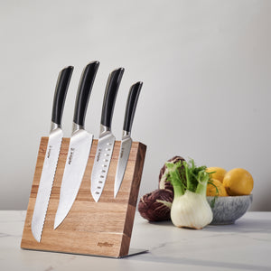 The Zyliss Comfort Pro Magnetic Knife Block displays four kitchen knives with black handles for efficient storage, with a bowl of vegetables and lemons on the countertop in the background.