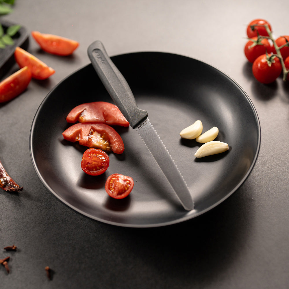 A Zyliss Tomato Knife Serrated 11cm/4½" with a black handle is shown beside a "4 for 3 mix & match" label on a plain light background, ideal for slicing tomatoes.