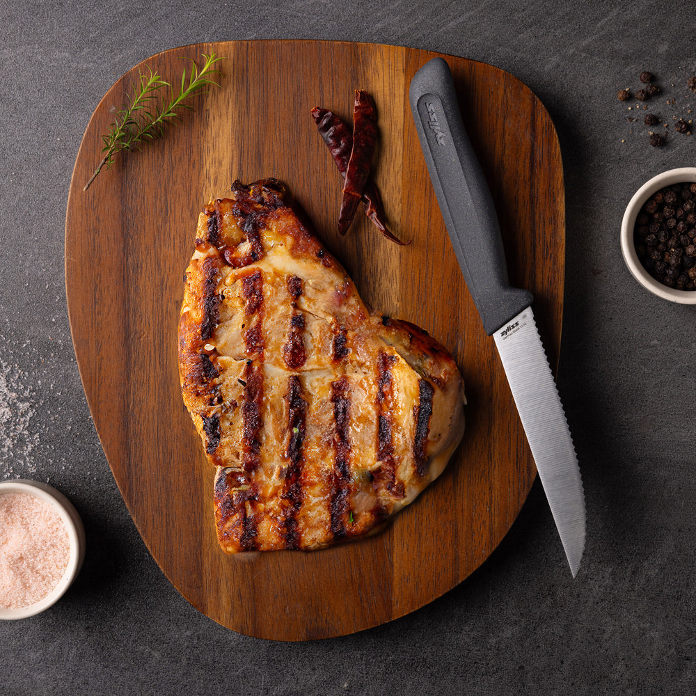 The Zyliss Steak Knife Serrated 11cm/4½", with a dishwasher-safe black handle, stands vertically against a plain background. A circular label nearby displays "4 for 3 mix & match.