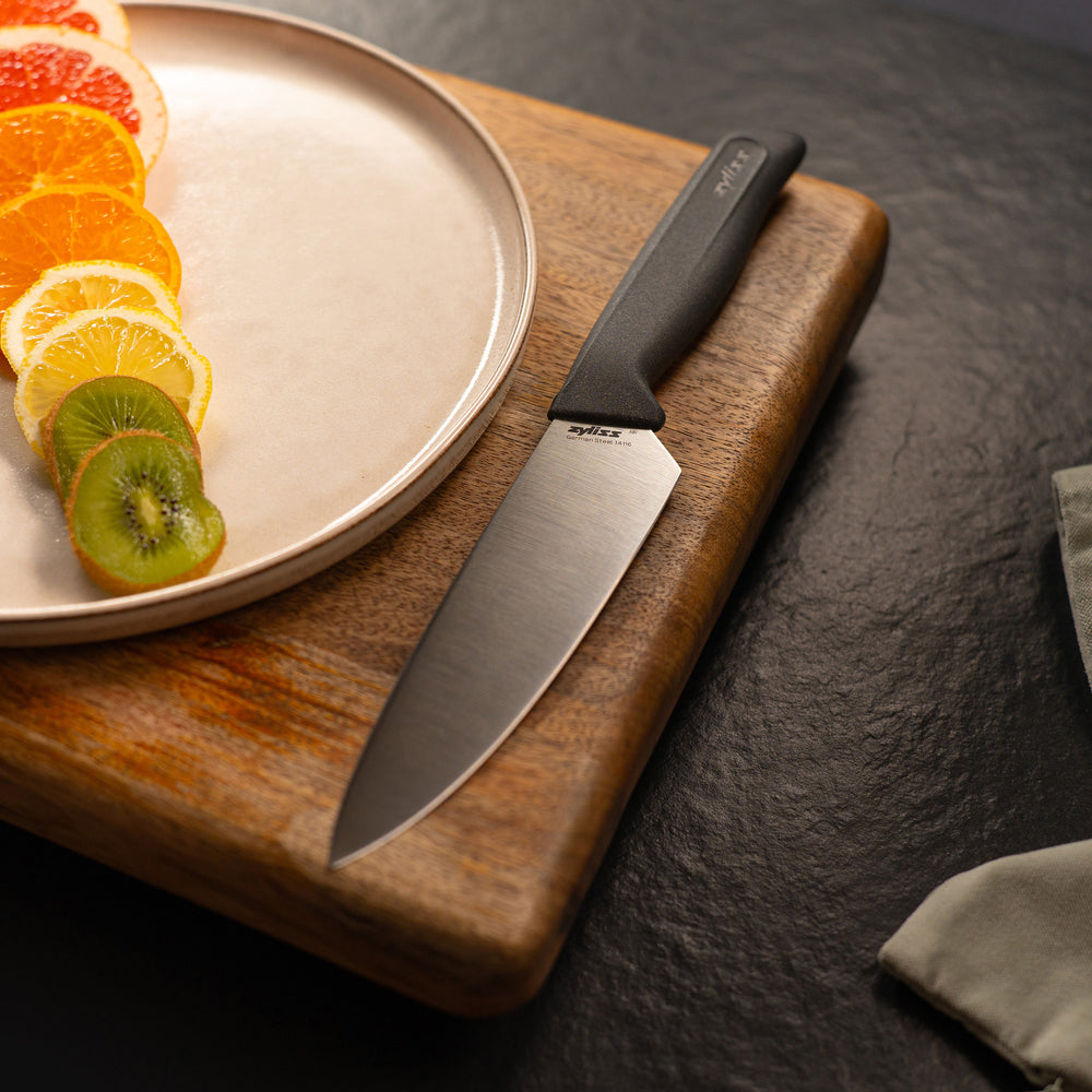 #15cm/6" 
A Zyliss Chef Knife with an ergonomic black handle and silver blade stands upright. A "4 for 3 mix & match" circular label appears in the top right, against a plain, light background.