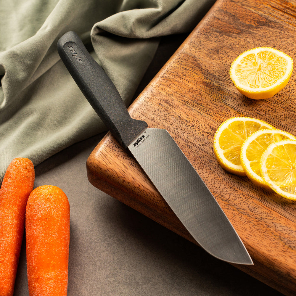 #15cm/6"
A Zyliss Santoku Knife 15cm / 6" with an eco-friendly black handle and wide silver blade stands upright. A circular "4 for 3 mix & match" label appears in the top right on a plain light gray background.