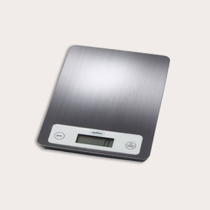 The Zyliss Electronic Measuring Scale features a brushed metal surface, white control panel with digital display, and two buttons (give and tare), making it perfect for precise cooking on any countertop.