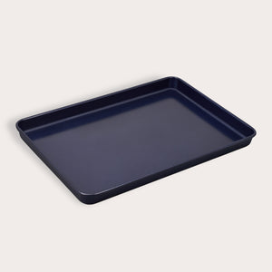 A Zyliss Durable Non-Stick Baking Tray, dark-colored with raised edges and made from non-stick carbon steel, is displayed against a plain light background.