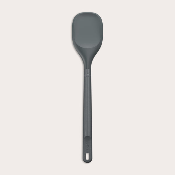 #large A Zyliss Spoontula with a dark gray, rounded silicone head and a long ergonomic handle, featuring a small hanging hole near the end, is displayed against a light background. #Large