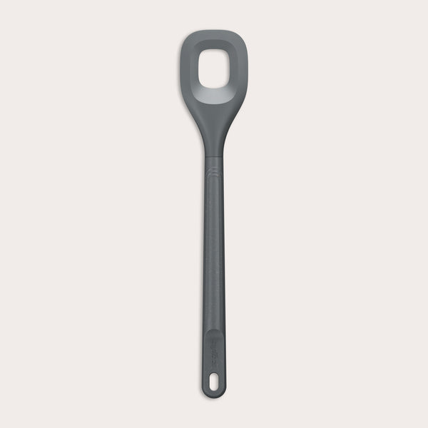 The Zyliss Square Mixing Spoon is a gray, heat-resistant silicone utensil with a long handle and a rectangular hole in the head. Shown on a plain light background, its dishwasher safe for easy cleaning.