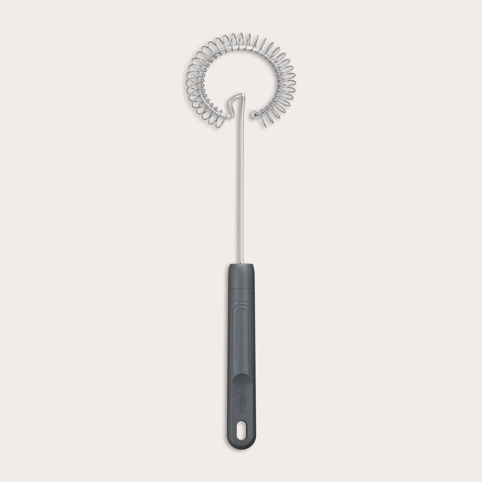 The Zyliss Gravy Whisk features a metal spiral and a dark plastic handle with a hanging hole. It is heat-resistant and shown against a plain light background.