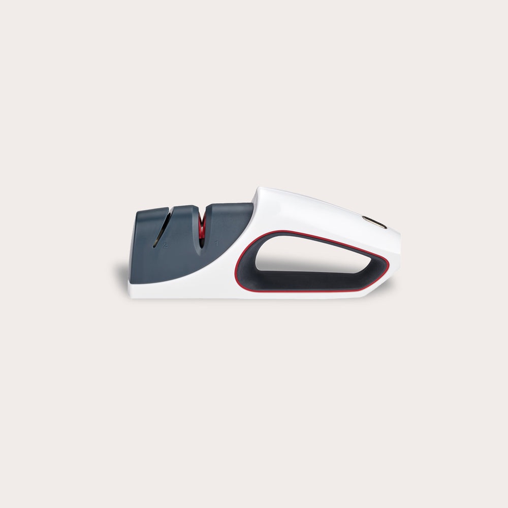 The Zyliss Control Knife Sharpener is a modern handheld sharpener for kitchen knives, featuring a white and gray body with red accents, two sharpening slots (including ceramic), shown against a plain light background.
