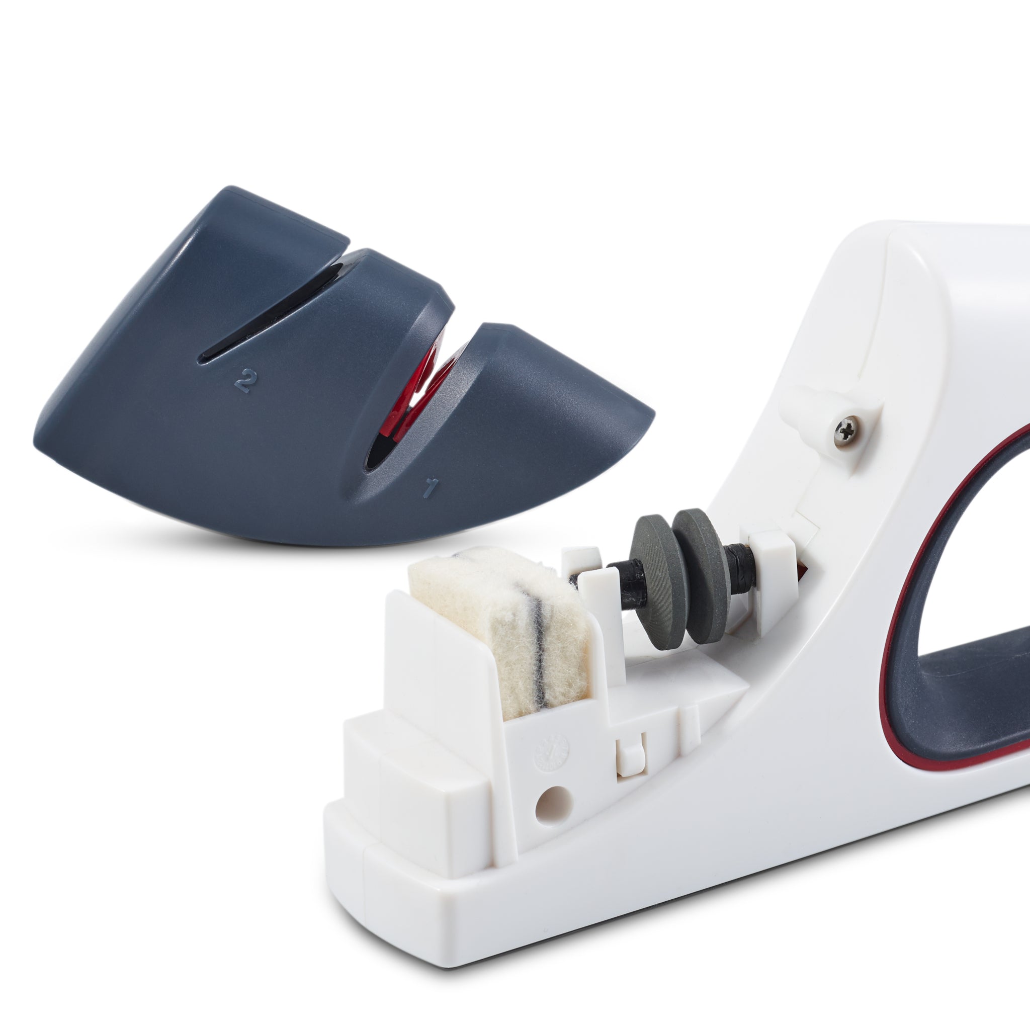 A close-up of a white and gray knife sharpener with two sharpening slots, showing the internal sharpening mechanism and felt pad. The detachable cover is placed beside the main device.