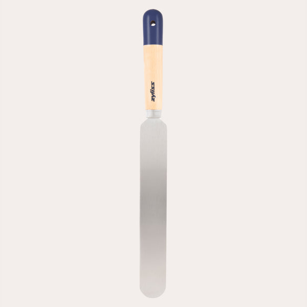 The Zyliss Beech Wood Palette Knife features an ergonomic tan beech wood handle with a dark blue tip and hanging hole, plus a long, flat stainless steel blade—ideal for spreading icing or frosting on cakes.
