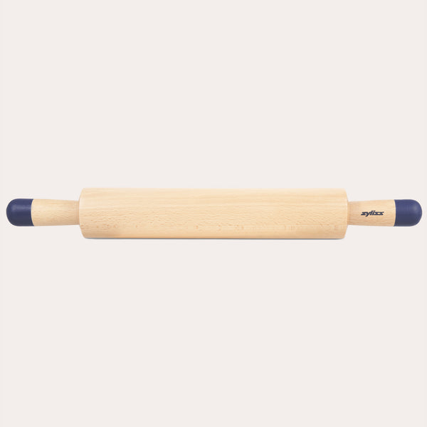 A Zyliss Beech Wood Rolling Pin with blue comfort-grip handles rests horizontally on a light background, showcasing the brand name for an essential tool in any kitchen.