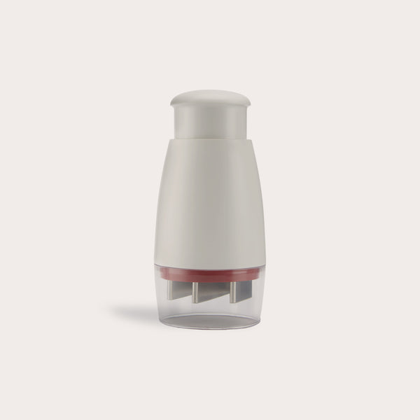 The Zyliss Zick-Zick Classic Food Chopper has a white and gray handheld design, rounded top, transparent base with metal blades, and is ideal for efficient kitchen storage. Shown against a plain light background.