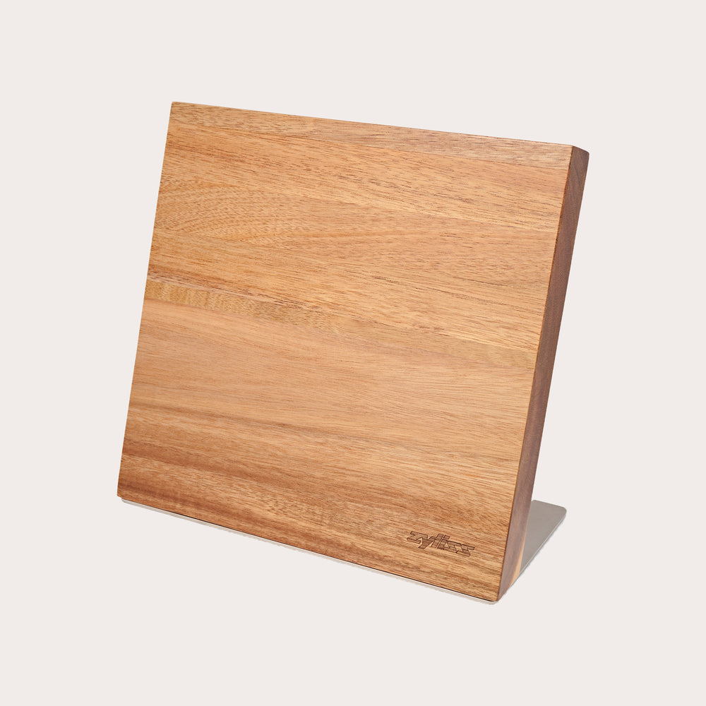 The Zyliss Comfort Pro Magnetic Knife Block features a simple, angled rectangular wooden design with a metal base, offering space-saving and stylish kitchen knife storage, shown against a plain white background.