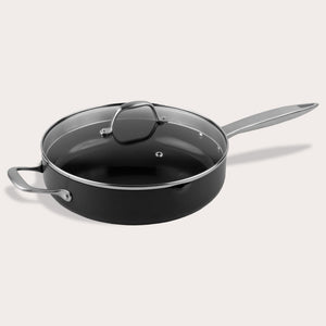 A Zyliss Ultimate Pro Ceramic Saute Pan With Lid, featuring a black nonstick surface, glass lid, long metal handle, and short helper handle, is displayed against a plain light background. 