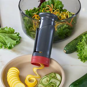 zyliss Spiralizer beside vegetable ribbons and a bowl of salad