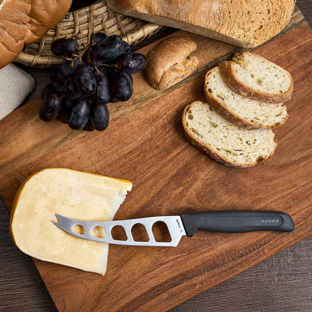 The Zyliss Cheese Knife 12.7cm/5" with a stainless steel blade, black wheat straw handle, and cut-out blade holes is displayed next to a "4 for 3 mix & match" circular label on a plain light background.