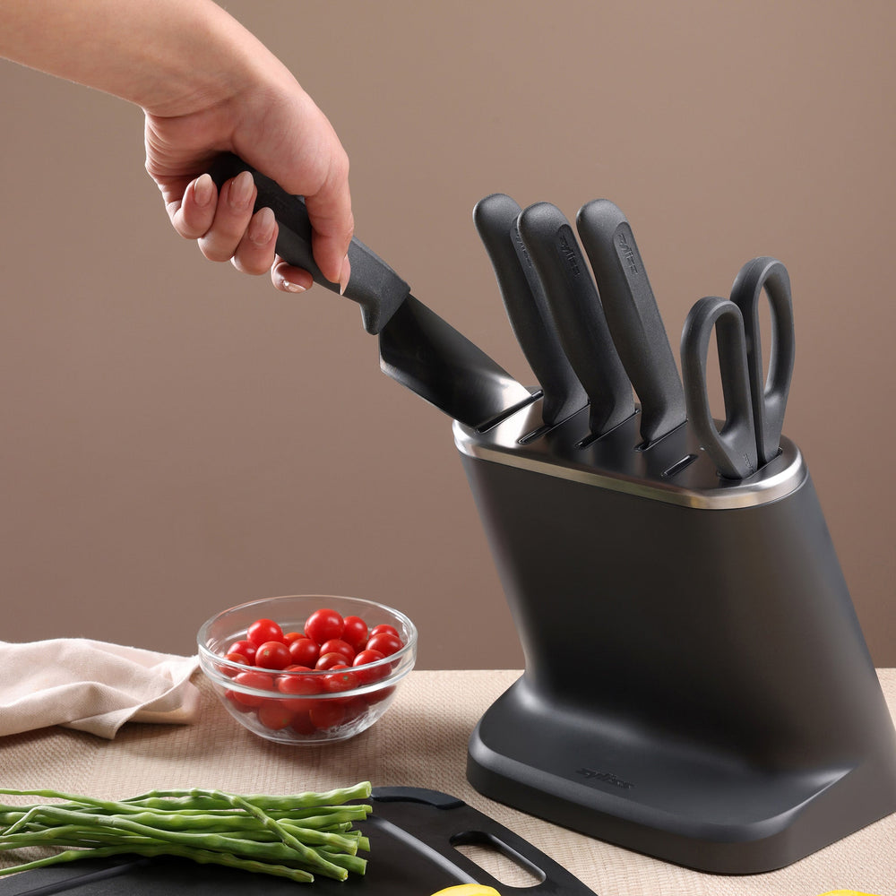 The Zyliss 8-Piece Knife Block features six Japanese stainless steel knives and kitchen scissors with matching dark gray handles in a modern block, shown on a light background.