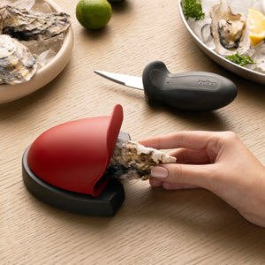 An oyster being placed in the holder of the zyliss oyster shucking set.