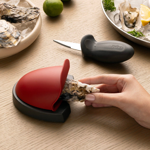 An oyster being placed in the holder of the zyliss oyster shucking set.