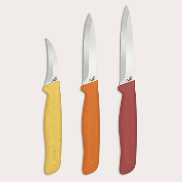 Three kitchen prep knives from the Zyliss Classic 3 Piece Peeling & Paring Knife Set are displayed upright against a light background. Each features a silver stainless steel blade and a colorful, speckled-texture handle in yellow, orange, or red. The rightmost knife includes a serrated blade—ideal for versatile peeling and paring tasks.