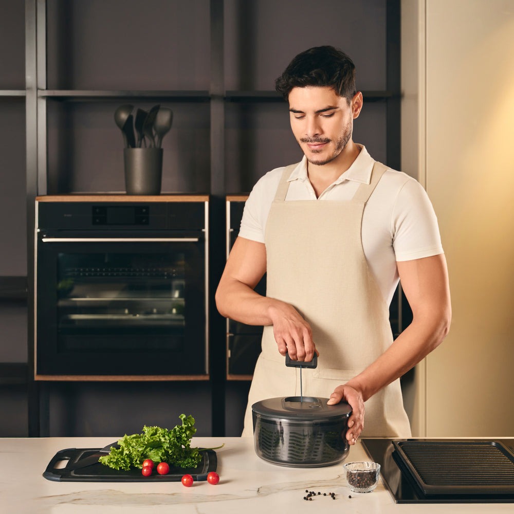 The Zyliss Healthy Meal Prep Bundle includes a black salad spinner, clear food storage container with black lid, manual veggie chopper, and black spatula—ideal essentials for healthy meal prep.