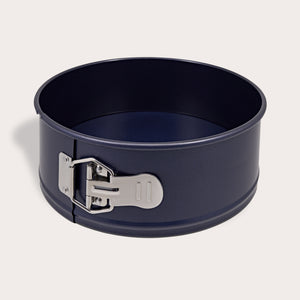 The Zyliss Durable Non-Stick Springform Cake Pan features a round black design with a silver latch, ideal for baking delicate cheesecakes, and is shown against a plain light background.
