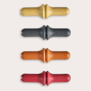 The Zyliss Corn Holders 4 Piece Set features cylindrical holders with ergonomic handles in yellow, black, orange, and red, each with a notch at one end, shown vertically on a light background.