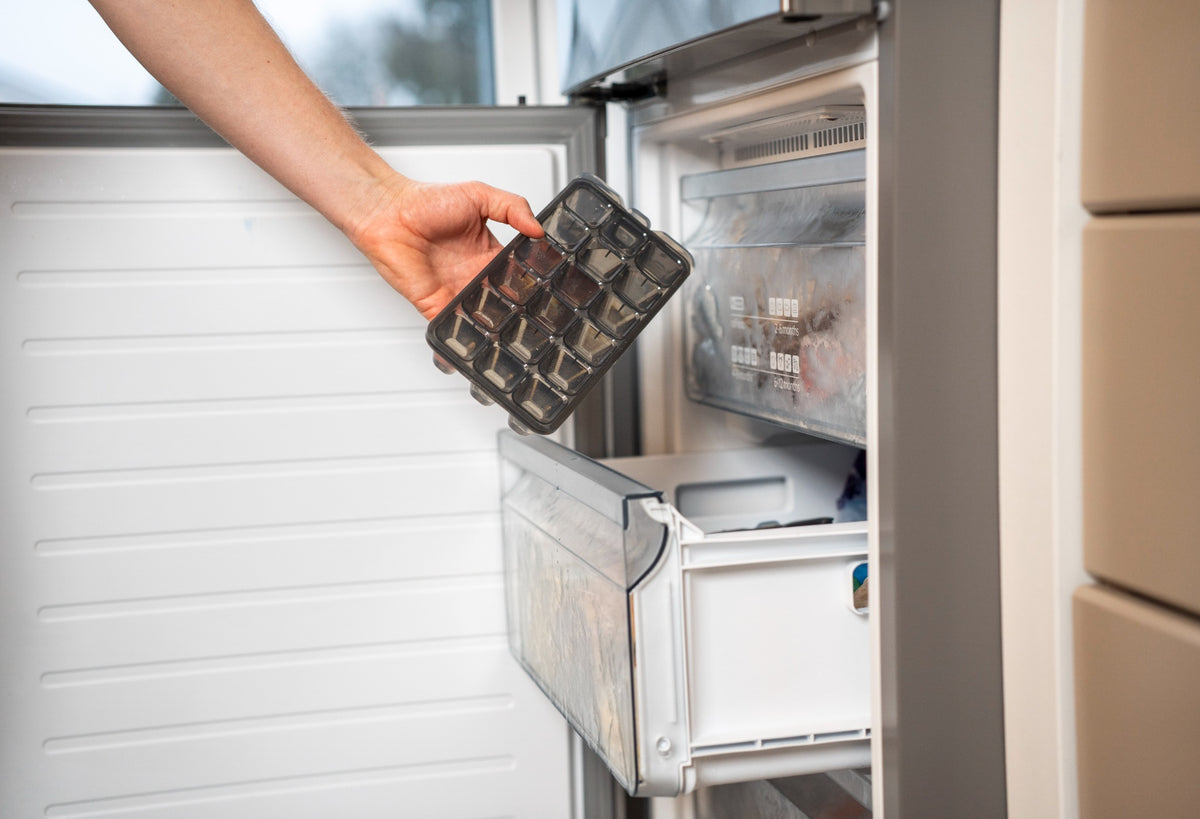 Placing a zyliss Classic Ice Cube Tray into a freezer drawer.