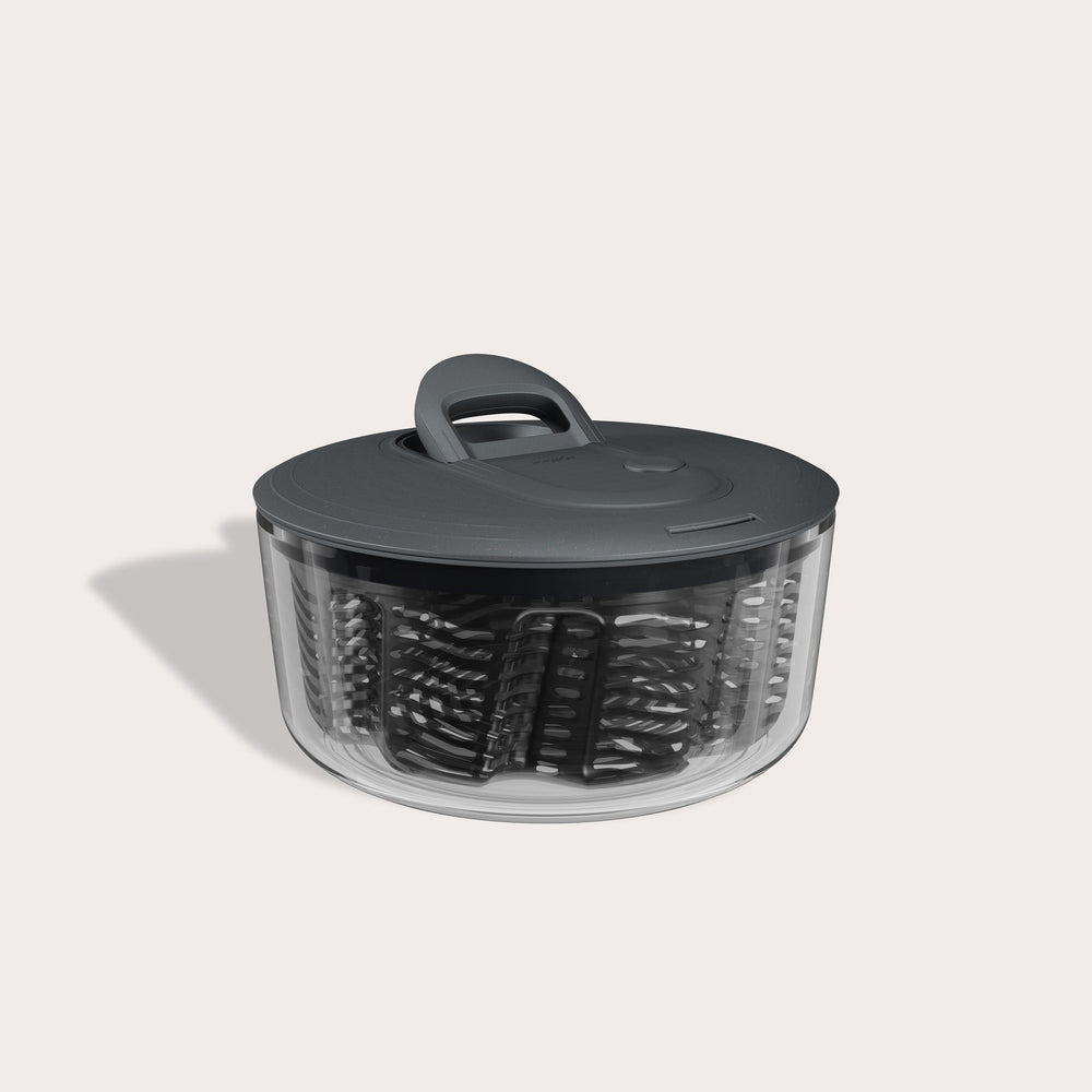 The Zyliss Easy Spin Salad Spinner features a clear plastic bowl, dark gray lid and handle, AquaVent technology, and a visible inner basket—making it a smart pick for any eco-friendly kitchen.