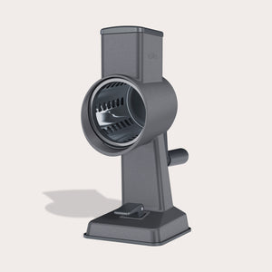 The Zyliss Gourmet Drum Grater, featuring a sturdy gray stainless steel design with handle and base, stands upright on a light background, highlighting its cylindrical grating drum.