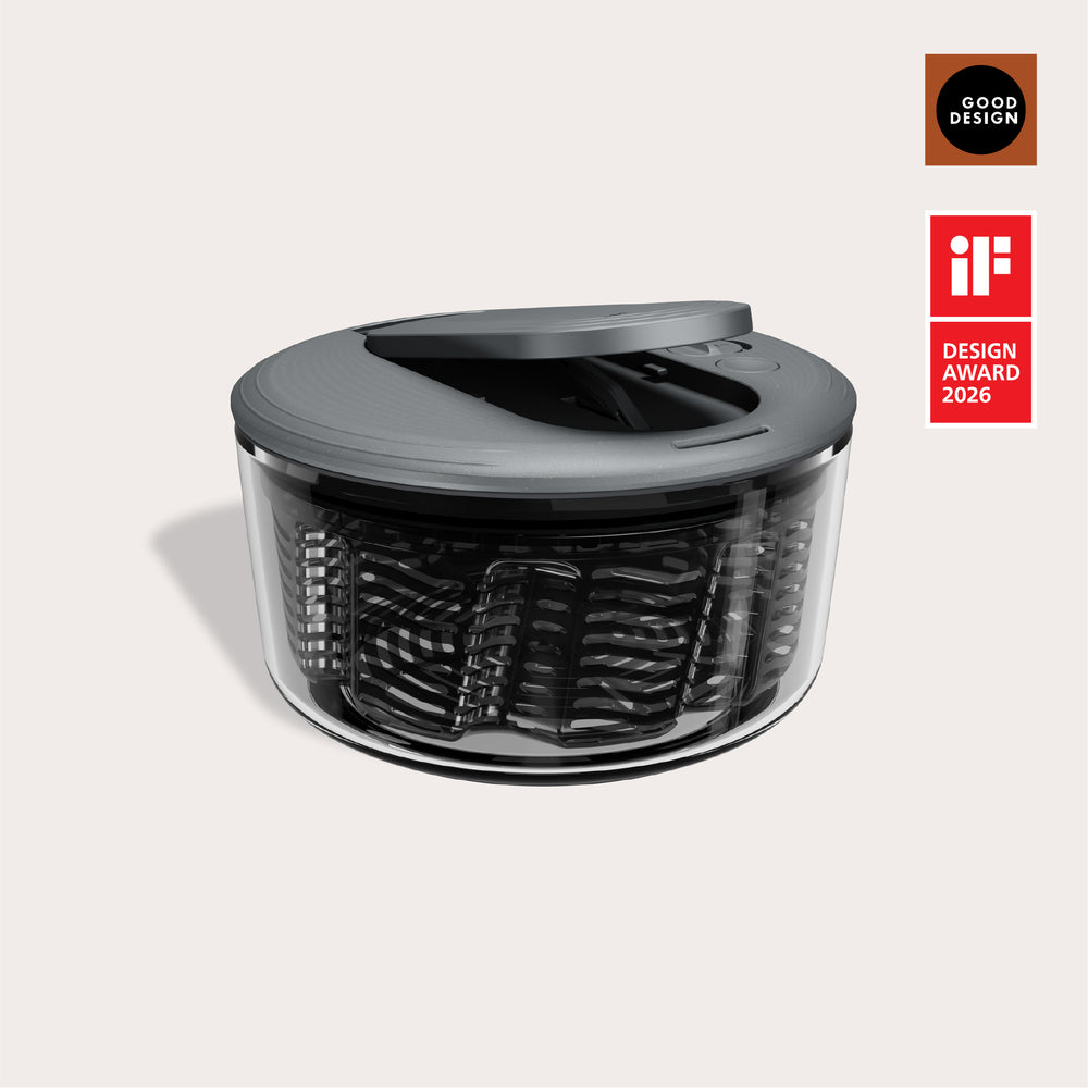 The Zyliss Swift Dry Salad Spinner, featuring a modern black and transparent design with a one-handed pump and lid, is shown against a light background. Good Design and iF Design Award 2026 logos appear on the right.