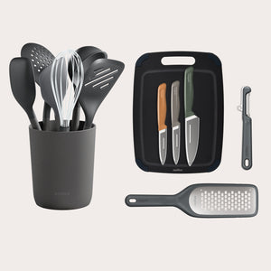 The Zyliss Kitchen Essentials Bundle features eco-friendly utensils with holder, three stainless steel knives on a cutting board, a veggie peeler, and handheld grater—all neatly arranged on a white background.