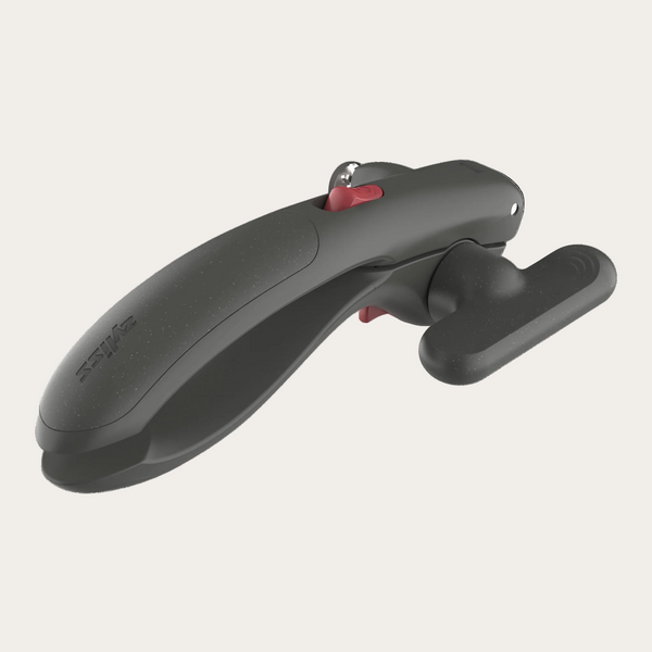A dark gray ergonomic tool with a textured finish, featuring a small red button and a silver metal ring, shown on a solid white background.