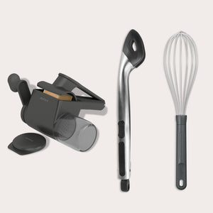 The Zyliss Cacio e pepe bundle—featuring a handheld cheese grater, metal slotted spoon with black handle, and wire whisk—is arranged side by side on a light background, perfect for crafting restaurant-quality pasta at home.