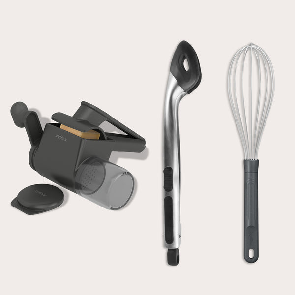 The Zyliss Cacio e pepe bundle—featuring a handheld cheese grater, metal slotted spoon with black handle, and wire whisk—is arranged side by side on a light background, perfect for crafting restaurant-quality pasta at home.