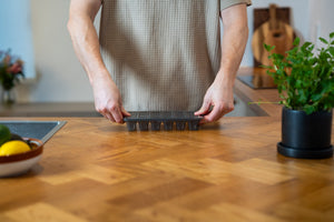 Closing the lid of a zyliss Classic Ice Cube Tray on a kitchen counter.