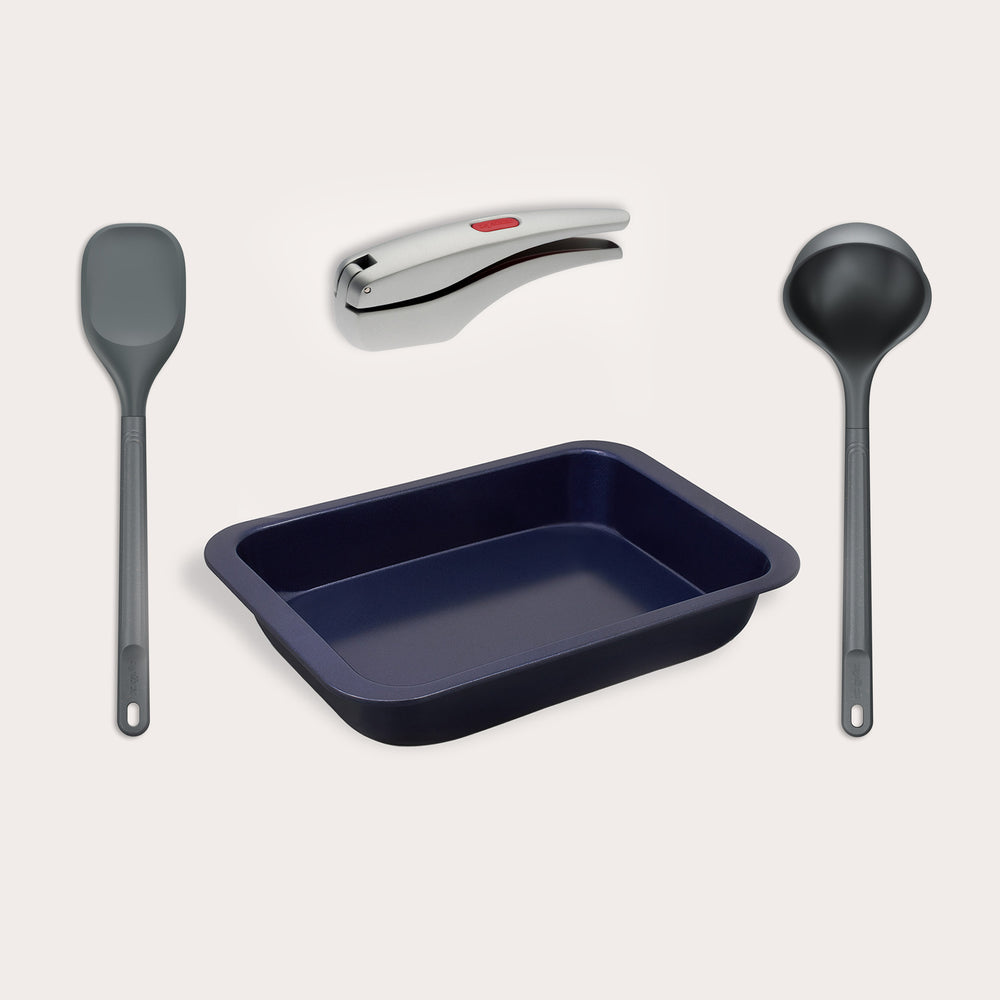 The Zyliss Soup Prepping Bundle includes a grey spatula, black ladle for soups, silver detachable handle with red button, and a dark blue rectangular baking pan—all displayed on a light background.