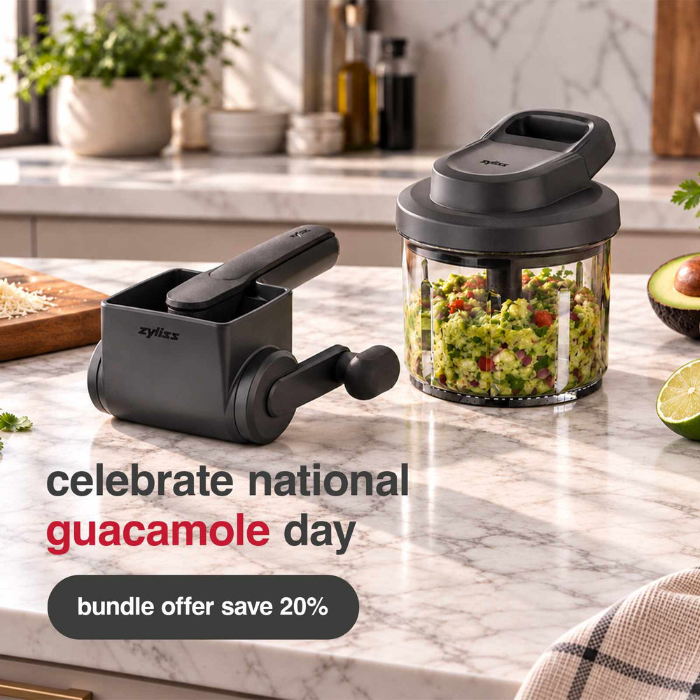 On a kitchen countertop, the Zyliss guacamole prep bundle—with a handy manual chopper filled with guacamole, limes, and herbs—makes preparing fresh dips easy. Celebrate National Guacamole Day with 20% off! Upgrade your kitchen routine with the efficient Zyliss manual chopper and enjoy homemade guacamole in minutes.